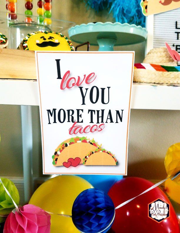 there is a sign that says i love you more than tacos with balloons in the background