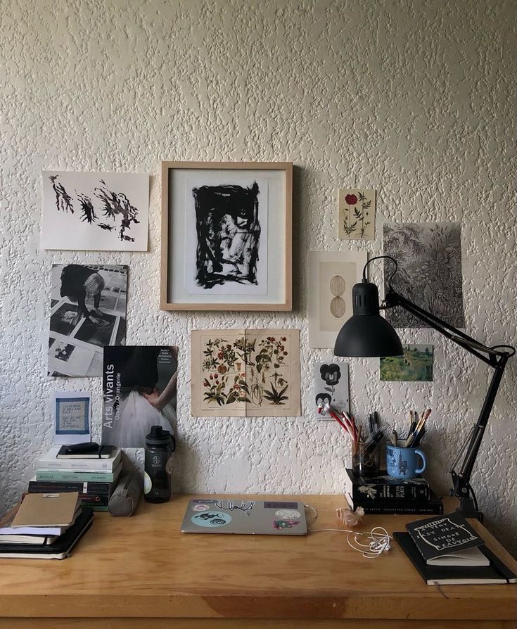 a wooden desk topped with pictures and a lamp