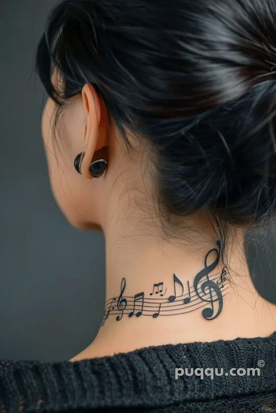 the back of a woman's neck with musical notes tattooed on her left side