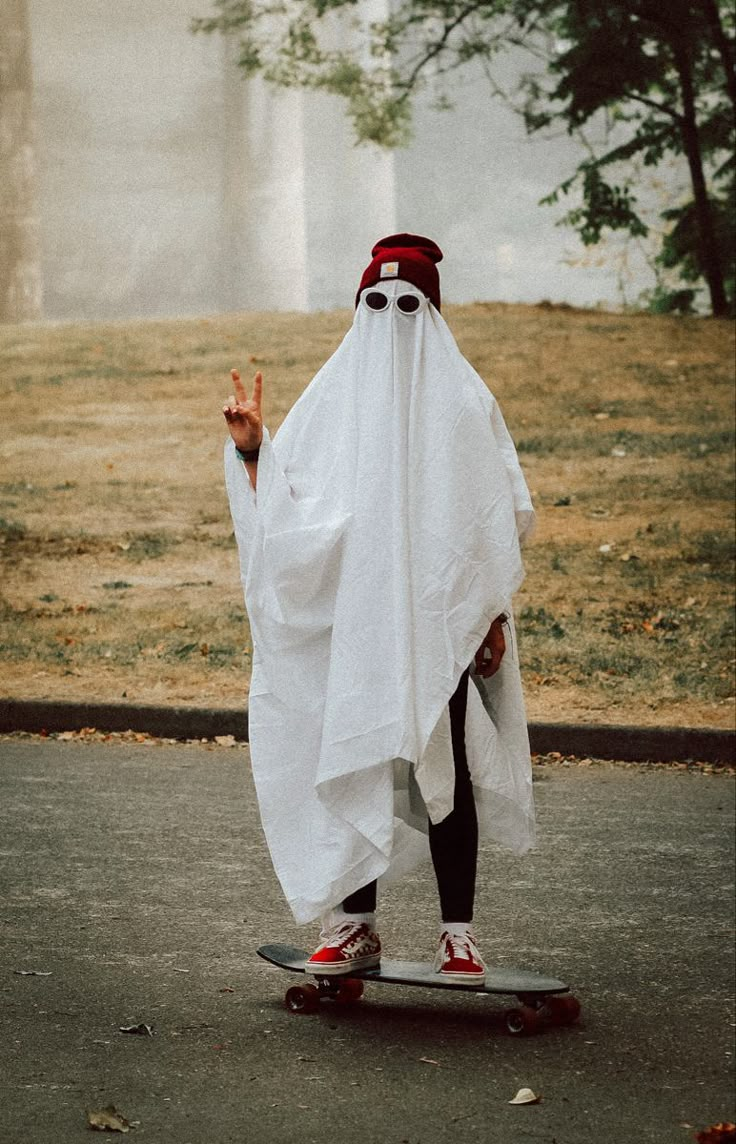 a man dressed as a ghost riding a skateboard