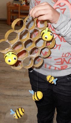 a young boy is playing with some paper honeybees on the floor in front of him