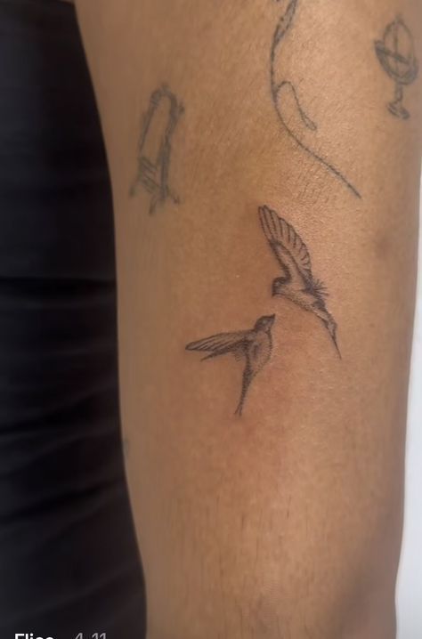 a woman's arm with two birds on it and one bird flying in the air