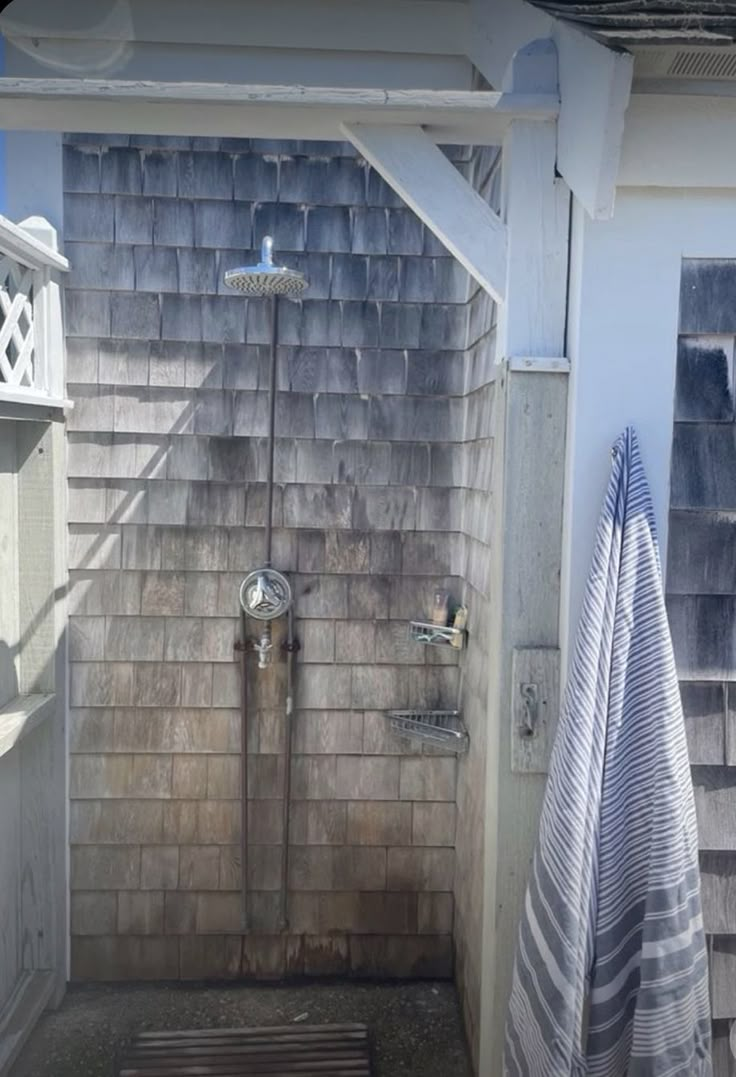 a bathroom with a shower and towels hanging on the wall next to it's door