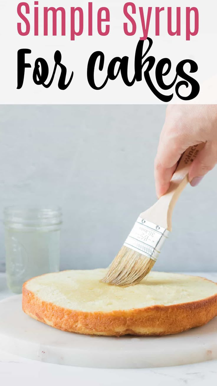 a person using a brush to paint a cake on a white plate with the words, simple syrup for cakes