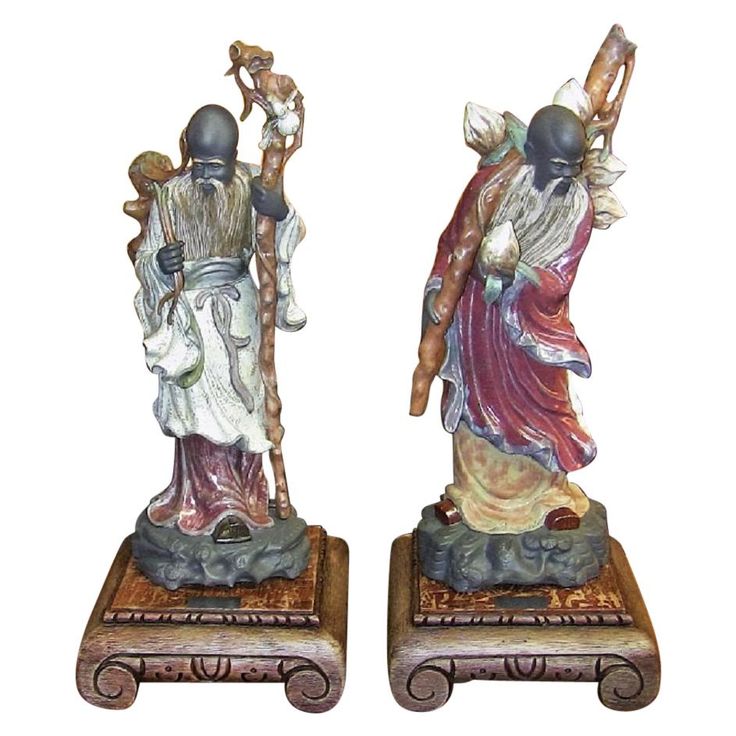 two figurines are sitting on small wooden bases