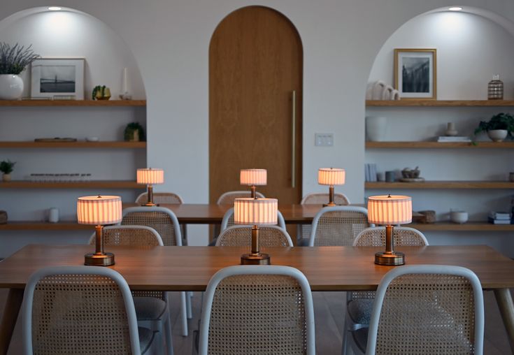 an empty dining room with white chairs and wooden tables