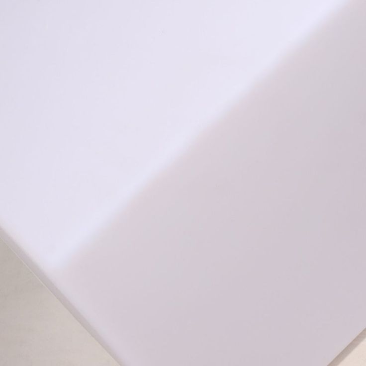 a close up view of the top of a white bed with no sheets on it