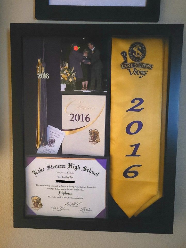 an award plaque is hanging on the wall next to a yellow tie and other items