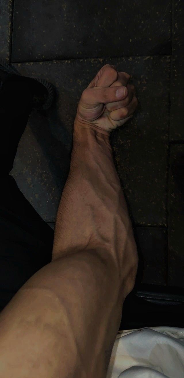 a man laying on top of a bed with his foot up against the wall next to him