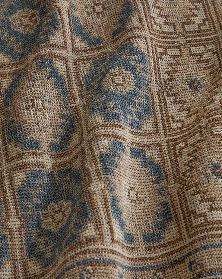 close up view of the blue and brown pattern on an old fabric textured with wool