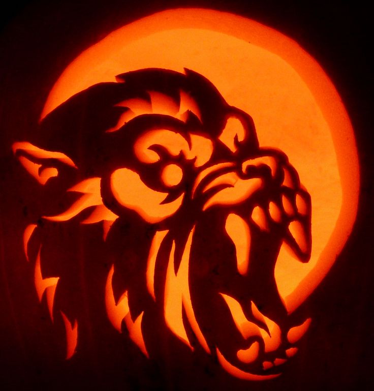 a carved pumpkin with an image of a lion on it's face and the moon in the background