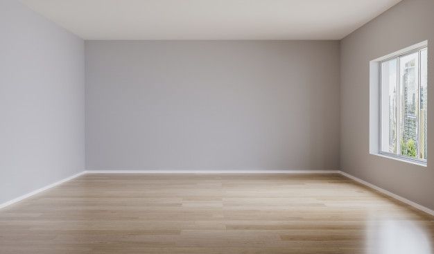 an empty room with white walls and wood flooring is seen from the corner window