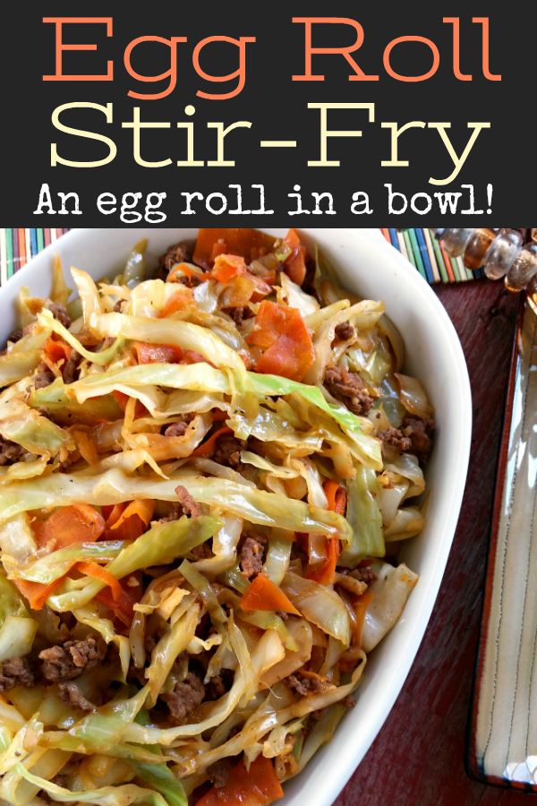 an egg roll stir fry in a bowl on top of a wooden table next to silverware