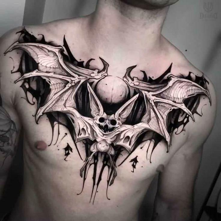 a man's chest with a bat tattoo on it