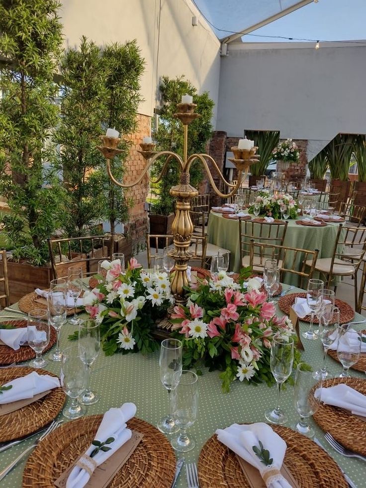 the table is set for an event with flowers and greenery in baskets on it