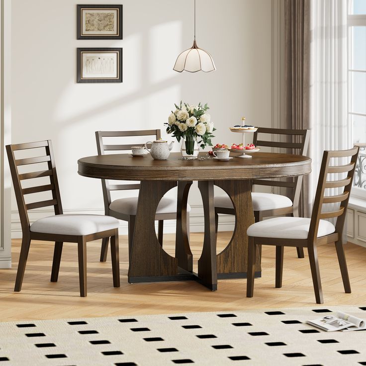 a dining table with four chairs and a vase on the table in front of it