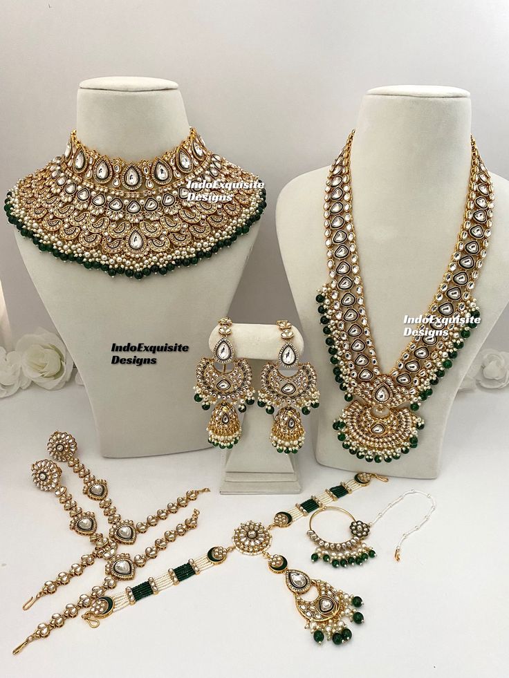 three necklaces and two earrings on display