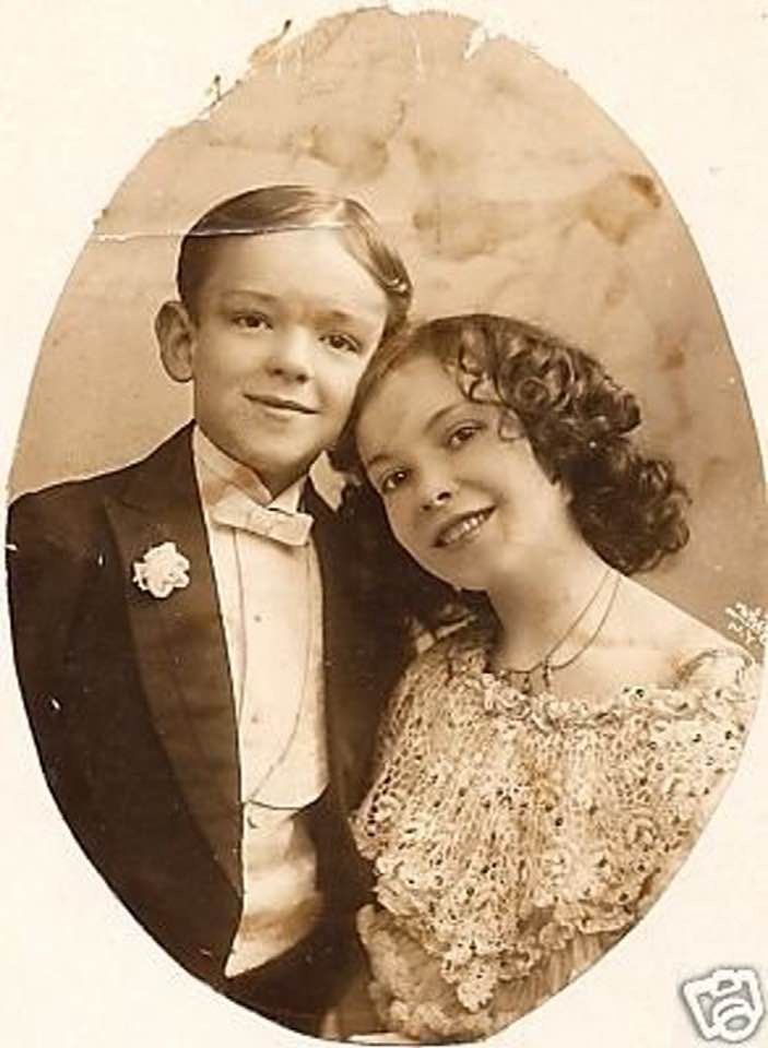 an old photo of two children posing for a picture in formal dress and tuxedo