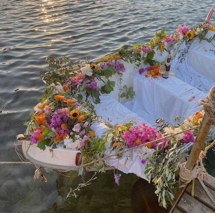 a row boat with flowers on it is tied to the dock