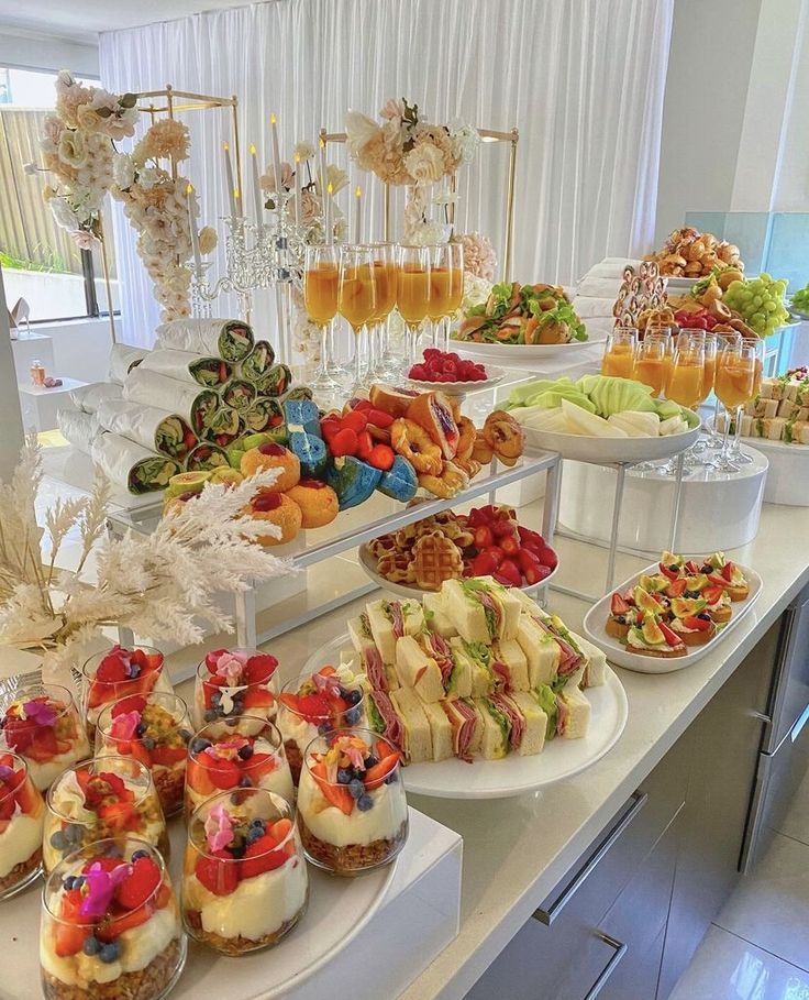 an assortment of desserts are displayed on the buffet table