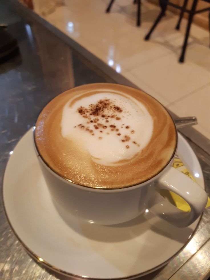 a cappuccino is sitting on a saucer