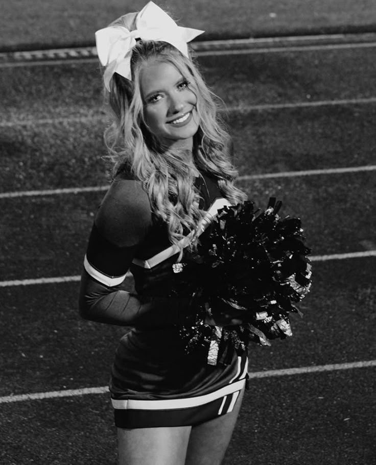 a cheerleader is smiling and holding her pom - poms