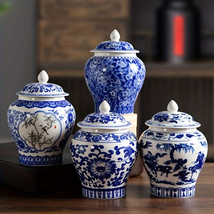 three blue and white vases sitting on top of a wooden table