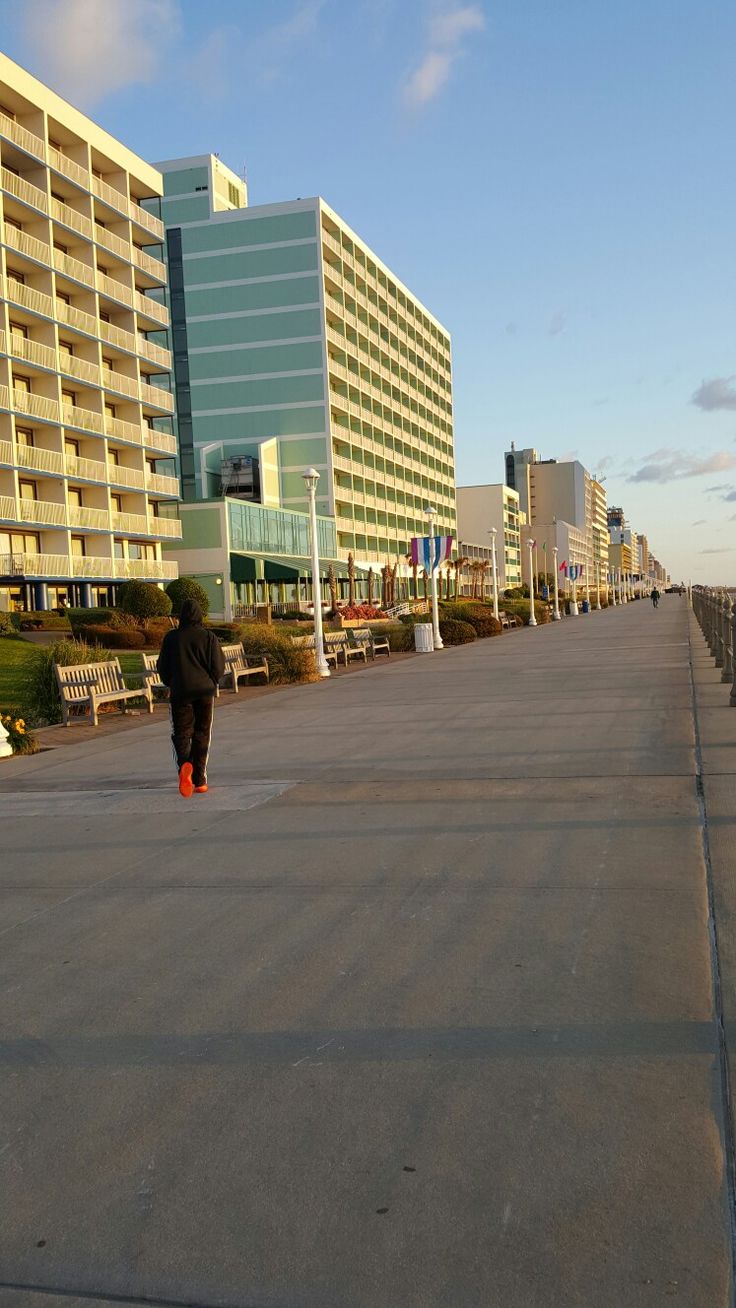 a person is walking down the street in front of some buildings and beachfronts