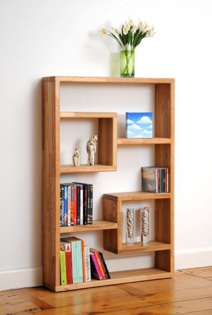 a wooden shelf with books and vase on top