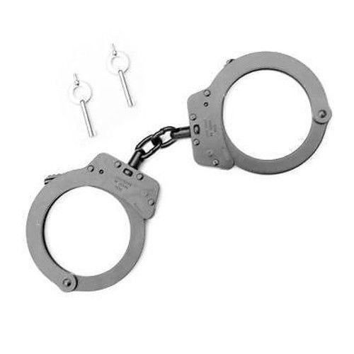 two handcuffs are chained to each other on a white background, with one being held by a metal chain