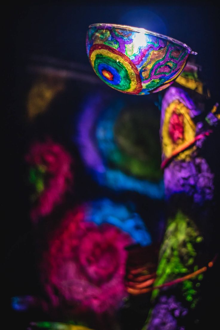 a colorful glass bowl sitting on top of a table