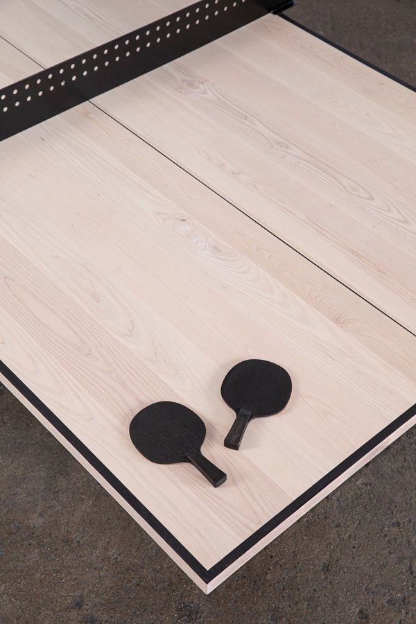 two ping pong paddles sitting on top of a wooden table