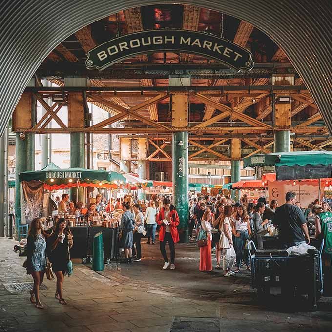 an outdoor market with lots of people walking around