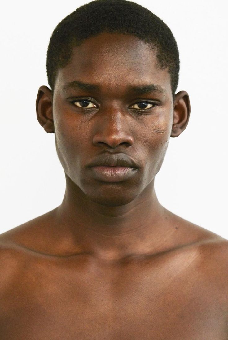 a young man with no shirt on posing for a photo in front of a white background