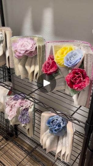 there is a rack that has many different flowers on the clothes hang from it's sides