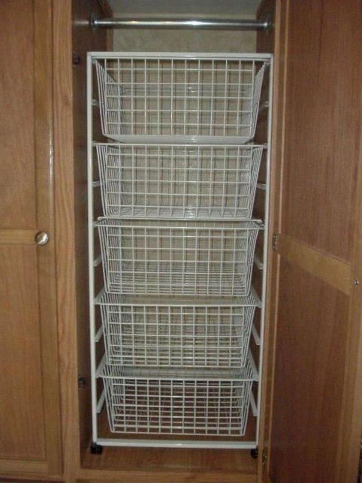 the closet door is open and there are wire baskets in it on the bottom shelf