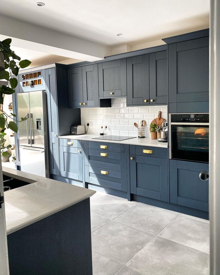 a kitchen with blue cabinets and white counter tops