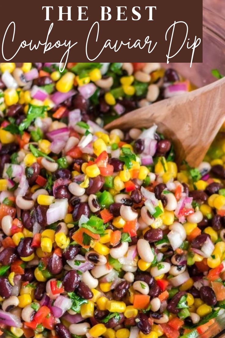 a wooden spoon in a bowl filled with beans and veggies