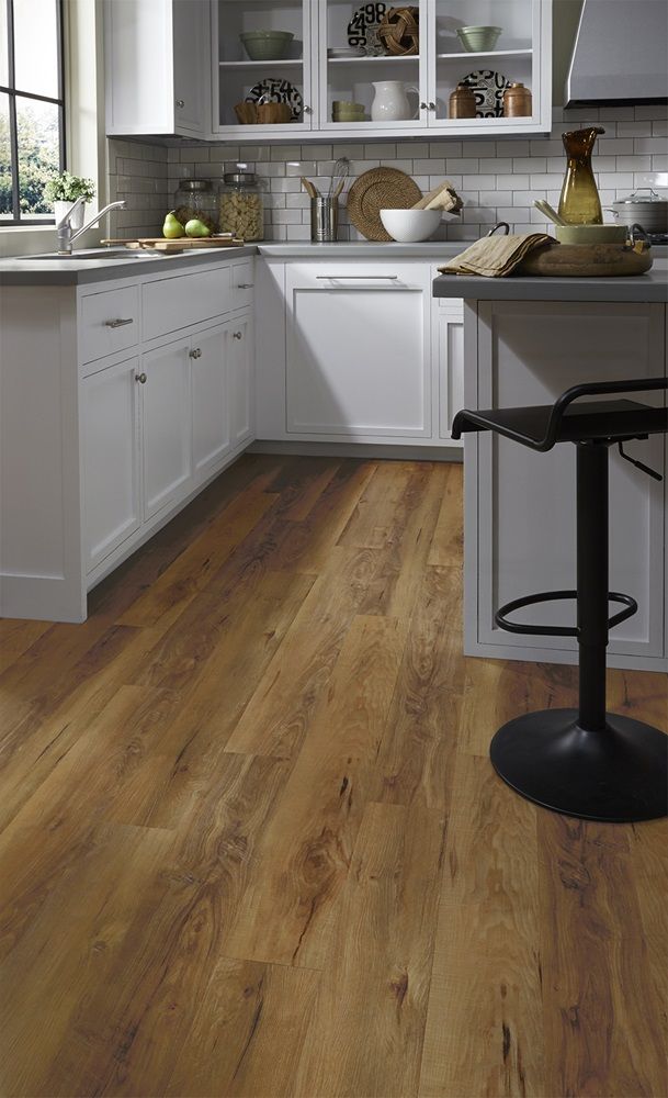 a kitchen with wooden floors and white cabinets