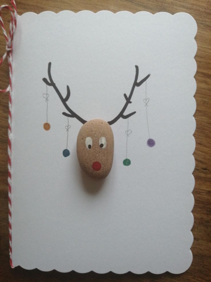 a rock with a reindeer's head on it is sitting next to a card