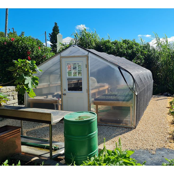 a small greenhouse in the middle of a garden