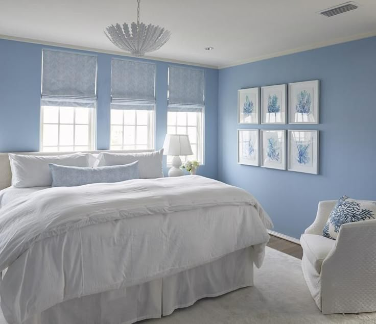 a bedroom with blue walls and white furniture