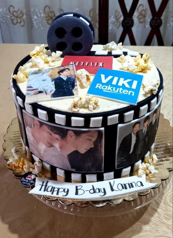 a cake decorated with pictures and film reels on it's side, sitting on a table