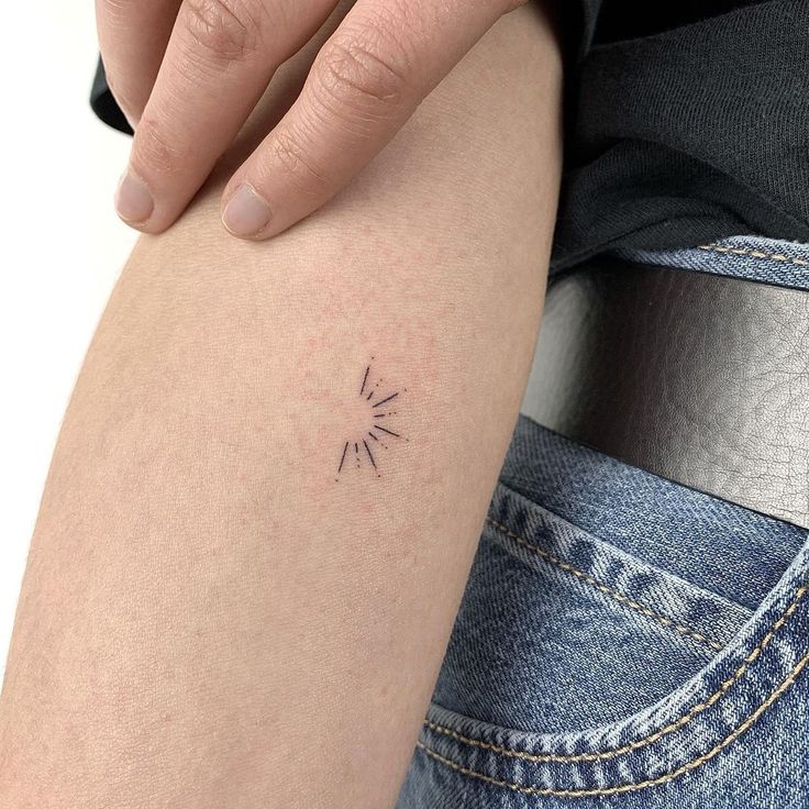 a person's arm with a small tattoo on the left side of her leg