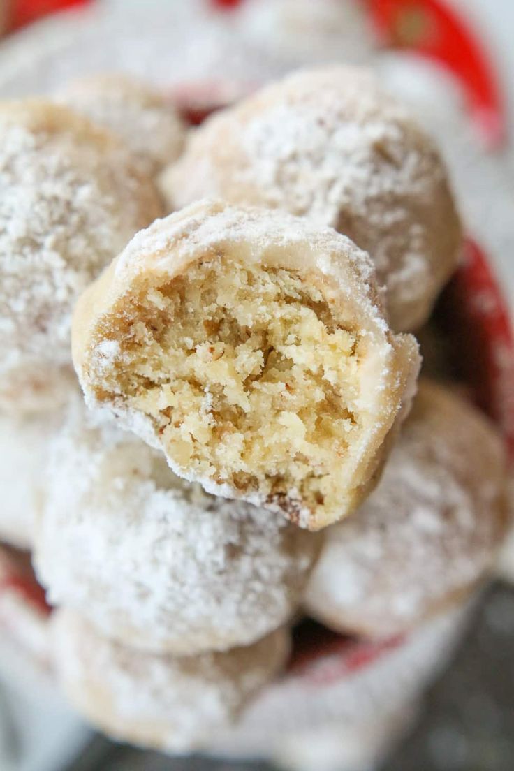 powdered sugar covered donuts in a red and white bowl