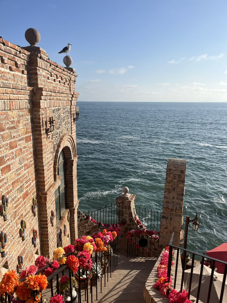 the stairs lead down to an outdoor ceremony area with flowers and seagulls on it