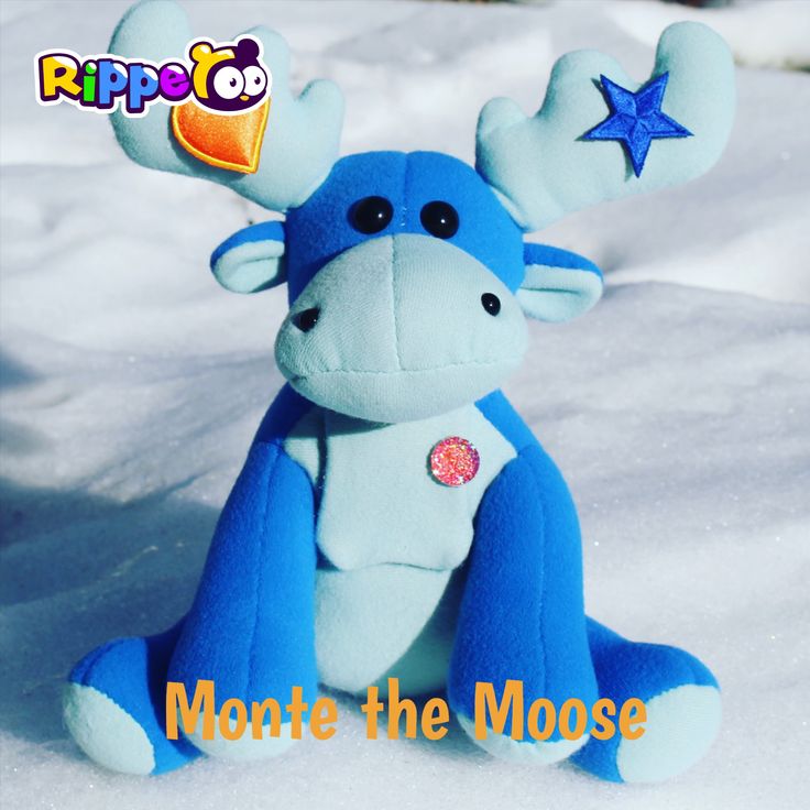 a blue stuffed animal sitting in the snow