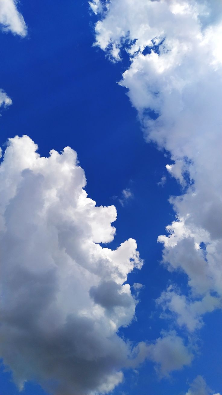 an airplane is flying in the blue sky with white clouds above it and on top of another plane