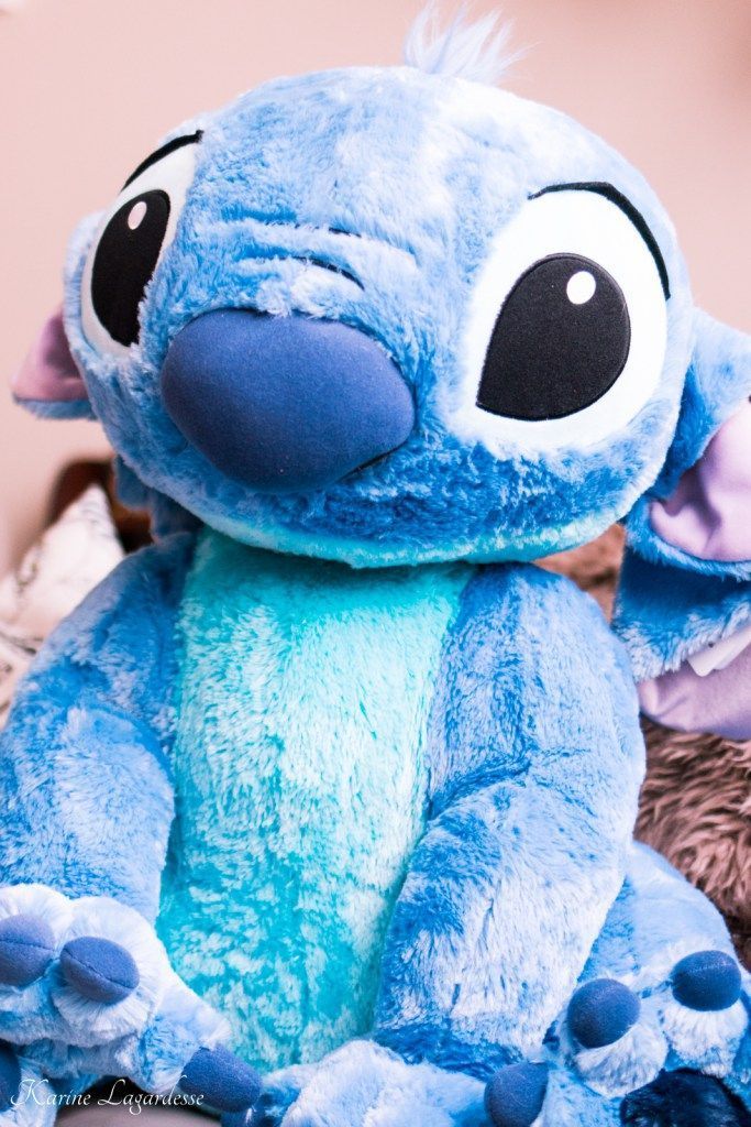 a blue stuffed animal sitting on top of a bed