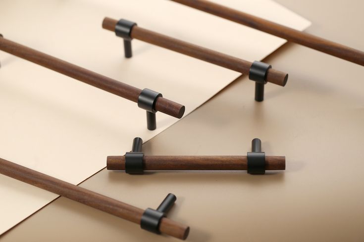 several pieces of wood are arranged on top of each other with black handles and bars